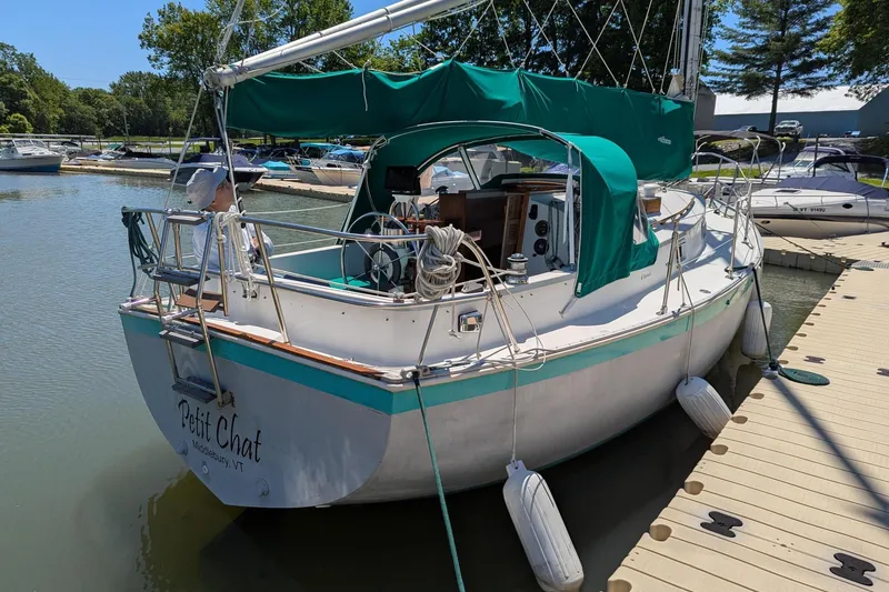 The Image of 1985 Nonsuch 26 Classic sailboat docked with green canopy and "Petit Chat" name. - 0