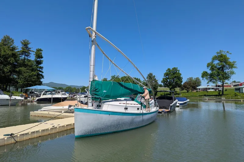 Slide: The Image of 1985 Nonsuch 26 Classic sailboat docked in a serene marina setting. - 1