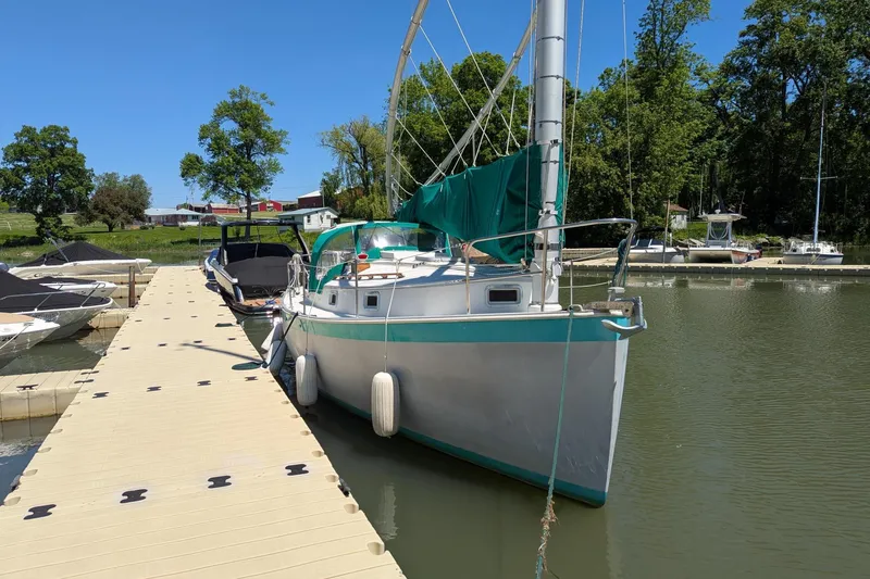 Slide: The Image of 1985 Nonsuch 26 Classic sailboat docked at a marina on a sunny day. - 2
