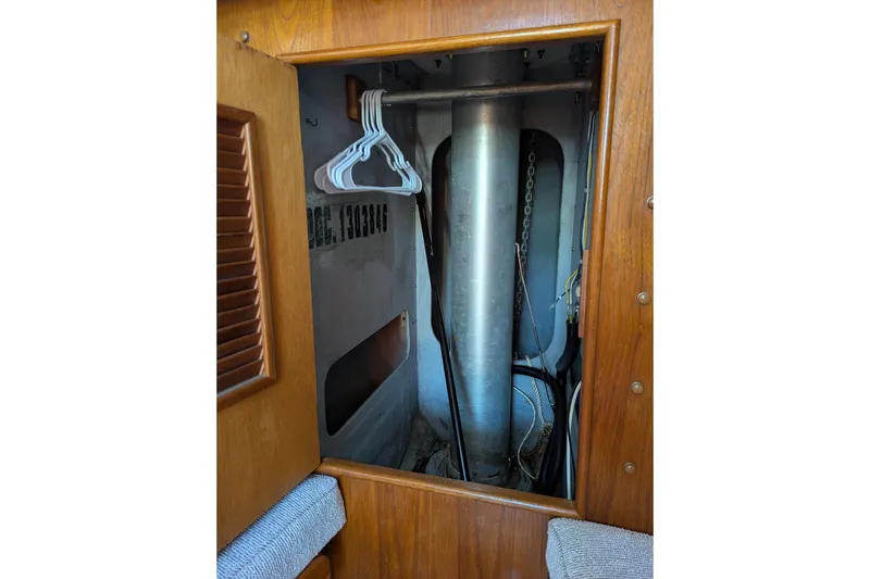 Slide: The Image of Interior view of a 1985 Nonsuch 26 Classic sailboat, featuring a storage compartment with hangers. - 3