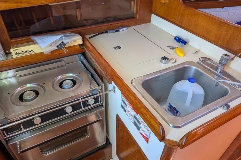 Slide: The Image of Compact kitchen area in a 1985 Nonsuch 26 Classic sailboat with stove and sink. - 7
