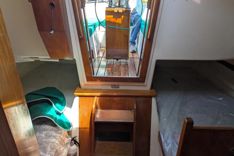 Slide: The Image of Interior view of a 1985 Nonsuch 26 Classic sailboat, showcasing wooden finishes and seating area. - 8