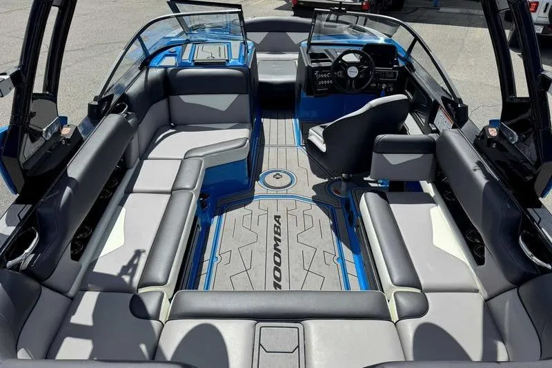 Slide: The Image of 2022 Moomba Kaiyen boat interior with gray and blue seating, modern dashboard, and spacious layout. - 3