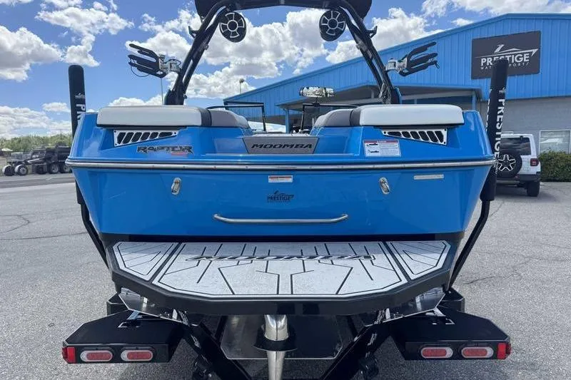 Slide: The Image of 2022 Moomba Kaiyen boat, blue exterior, rear view with speakers and swim platform. - 4