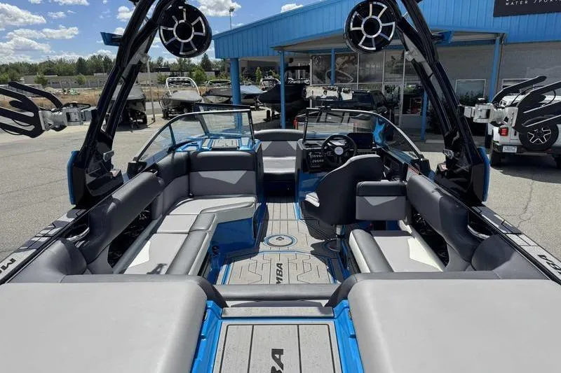 Slide: The Image of 2022 Moomba Kaiyen boat interior with seating and speakers, displayed outdoors at a dealership. - 5