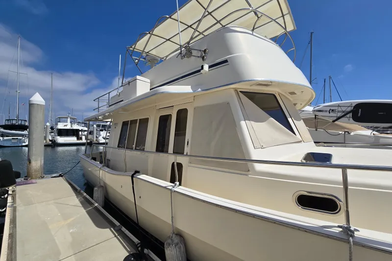 The Image of 2008 Mainship 400 Trawler docked at marina under clear blue sky. - 1