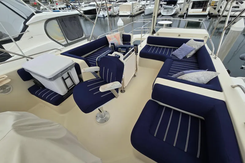 Slide: The Image of 2008 Mainship 400 Trawler interior with blue seating and marina view. - 10