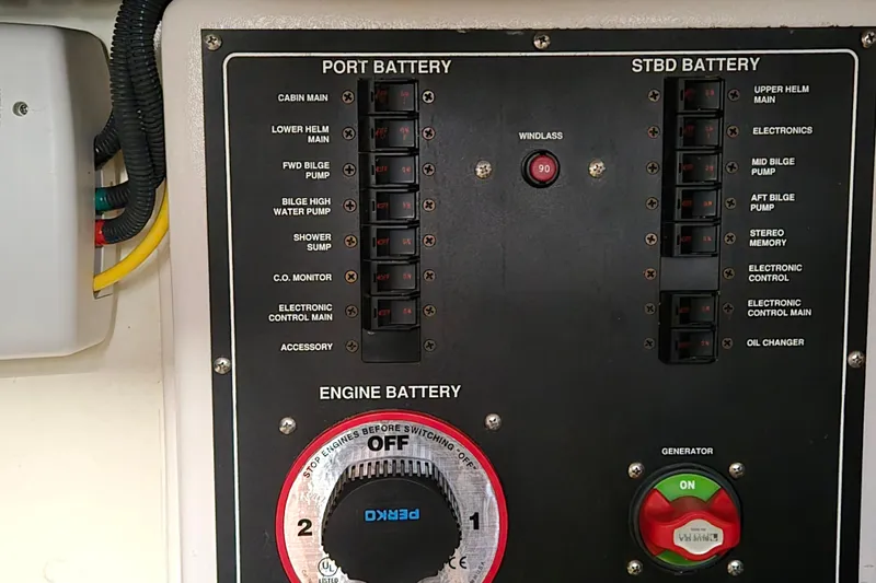 Slide: The Image of Control panel of a 2008 Mainship 400 Trawler, showing battery switches and generator controls. - 17