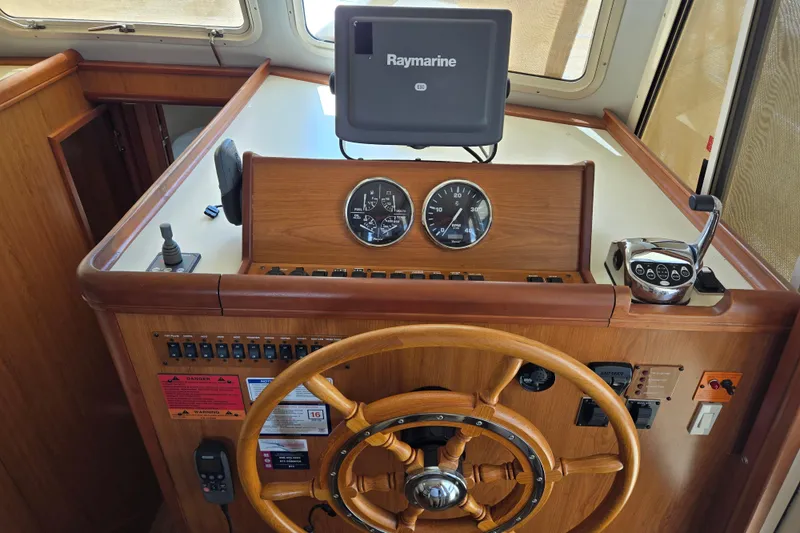 Slide: The Image of Helm of 2008 Mainship 400 Trawler with wooden wheel and Raymarine navigation system. - 20
