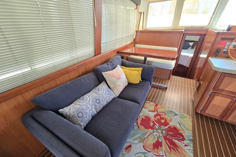Slide: The Image of Interior of 2008 Mainship 400 Trawler with cozy seating, colorful rug, and dining area. - 25