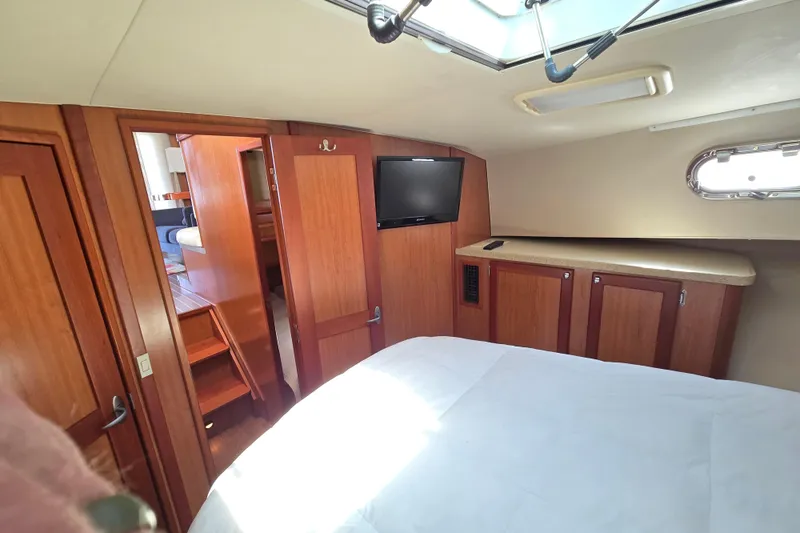 Slide: The Image of 2008 Mainship 400 Trawler cabin interior with wood paneling, TV, and natural light. - 27