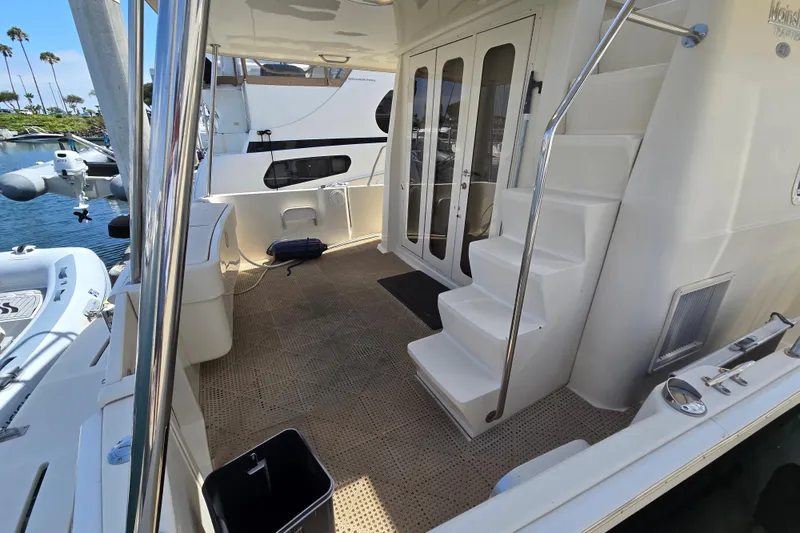 Slide: The Image of 2008 Mainship 400 Trawler deck with stairs and glass doors, docked at marina. - 3