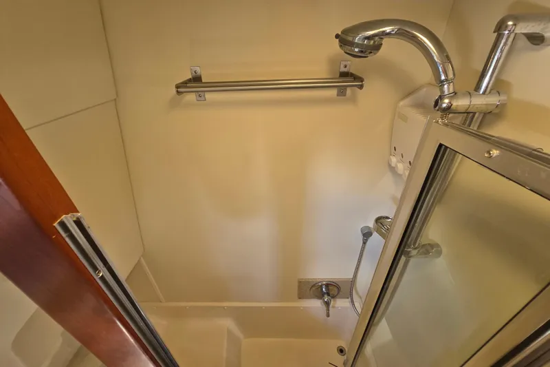Slide: The Image of Shower area in 2008 Mainship 400 Trawler, featuring chrome fixtures and glass door. - 30