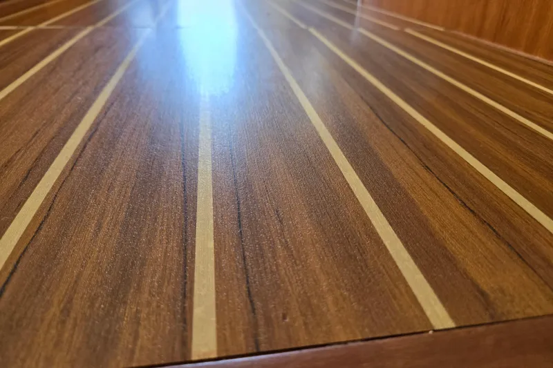 Slide: The Image of Polished wooden deck of 2008 Mainship 400 Trawler, showcasing elegant striped design. - 35