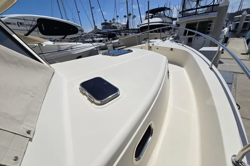 Slide: The Image of 2008 Mainship 400 Trawler docked, showcasing sleek deck design and marina surroundings. - 4