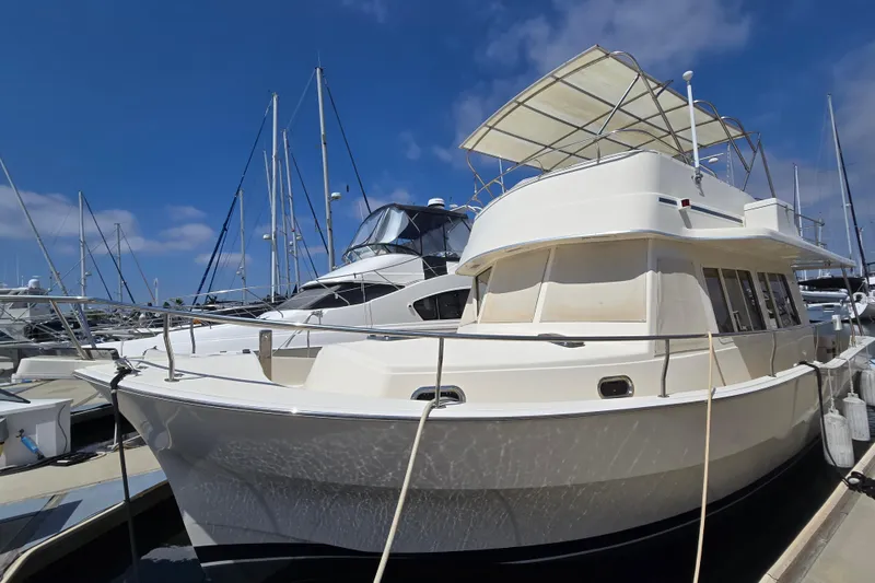 Slide: The Image of 2008 Mainship 400 Trawler docked at marina under clear blue sky. - 7