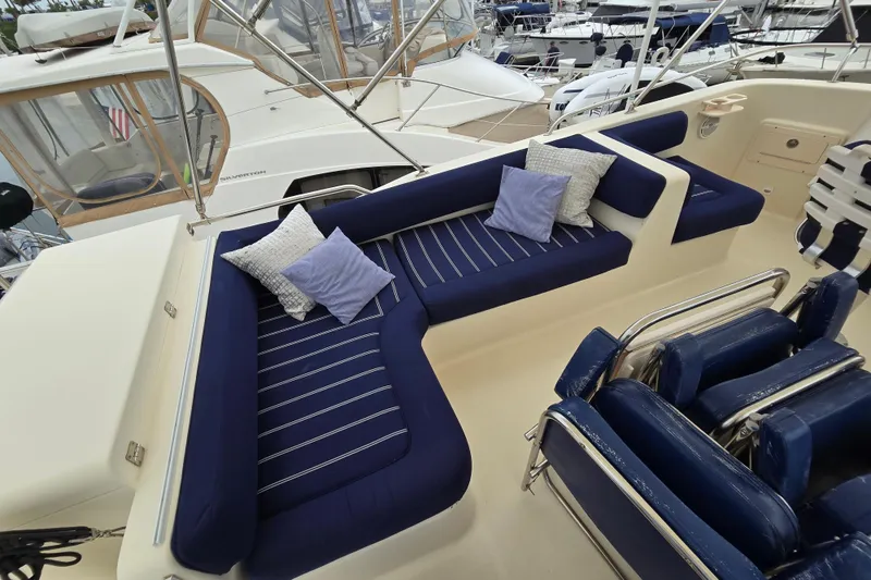 Slide: The Image of 2008 Mainship 400 Trawler with blue cushioned seating and pillows on deck. - 9