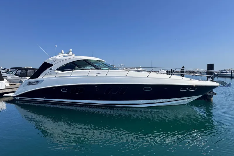 Slide: The Image of 2011 Sea Ray 540 Sundancer yacht docked in a marina under clear blue skies. - 1