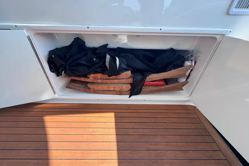 Slide: The Image of Storage compartment on 2011 Sea Ray 540 Sundancer yacht with wooden items and black fabric. - 21