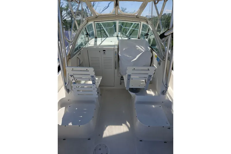 Slide: The Image of 2004 Pursuit 2470 Walkaround boat interior with seating and helm station. - 2