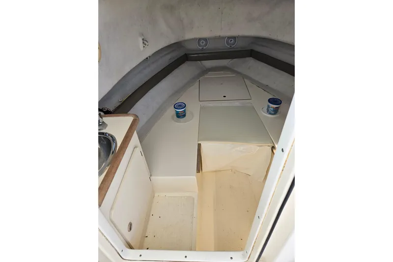 Slide: The Image of 2004 Pursuit 2470 Walkaround cabin interior with sink and storage compartments. - 5