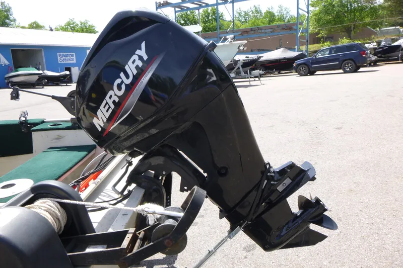 Slide: The Image of 1999 Smoker Craft 150 Stinger with Mercury outboard motor in a boatyard setting. - 14