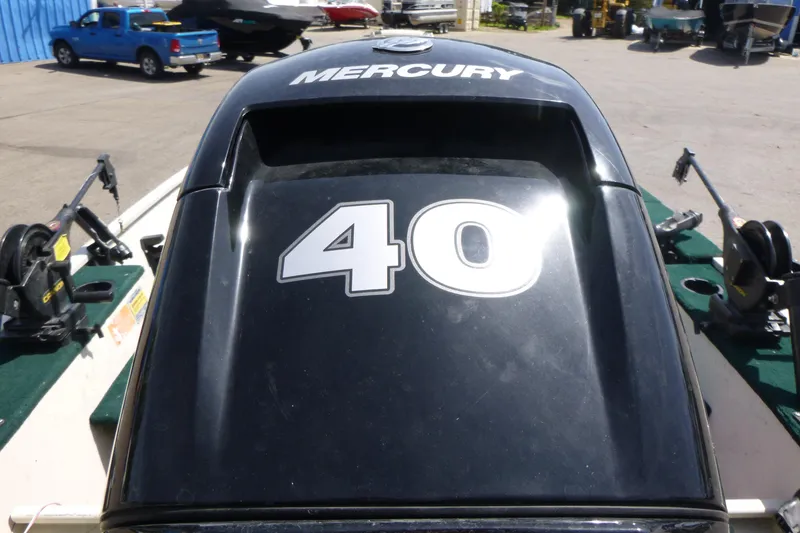 Slide: The Image of 1999 Smoker Craft 150 Stinger with Mercury 40 HP engine, parked outdoors. - 15