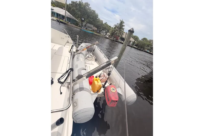 Slide: The Image of Inflatable dinghy on 2018 Fountaine Pajot Lucia 40 catamaran, docked by a serene waterfront. - 12