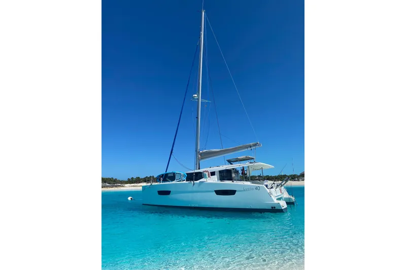 Slide: The Image of 2018 Fountaine Pajot Lucia 40 catamaran anchored in clear turquoise waters. - 2