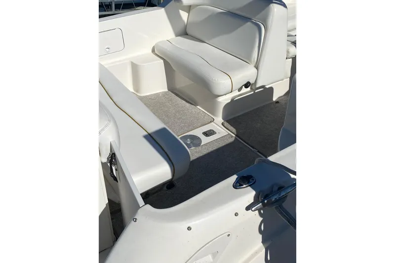 Slide: The Image of Interior view of a 2001 Sea Ray Sundancer 260 boat with white seating and carpeted floor. - 4