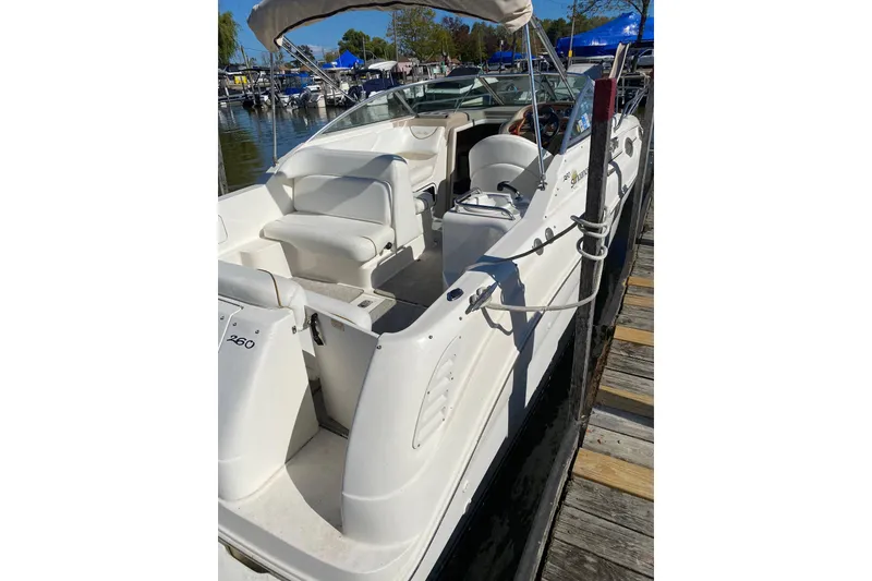 The Image of 2001 Sea Ray Sundancer 260 boat docked, featuring white seating and sleek design. - 2