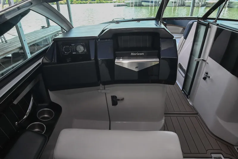 Slide: The Image of Interior of 2014 Four Winns H290 boat, featuring sleek dashboard and modern controls. - 16