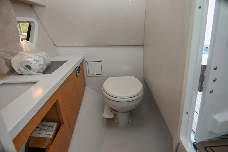 Slide: The Image of 2014 Four Winns H290 boat bathroom interior with toilet and sink. - 18