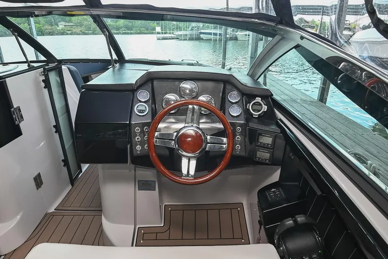 Slide: The Image of 2014 Four Winns H290 boat cockpit with sleek dashboard and wooden steering wheel. - 19