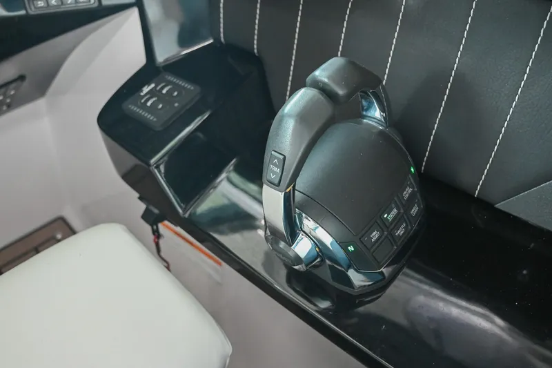 Slide: The Image of Control panel of a 2014 Four Winns H290 boat with sleek black and chrome design. - 21