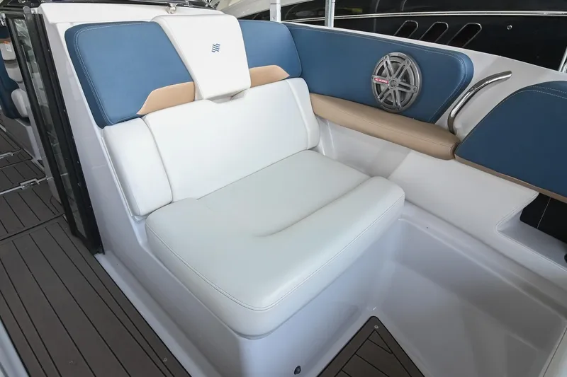 Slide: The Image of 2014 Four Winns H290 boat interior with white and blue seating, speaker, and teak flooring. - 29