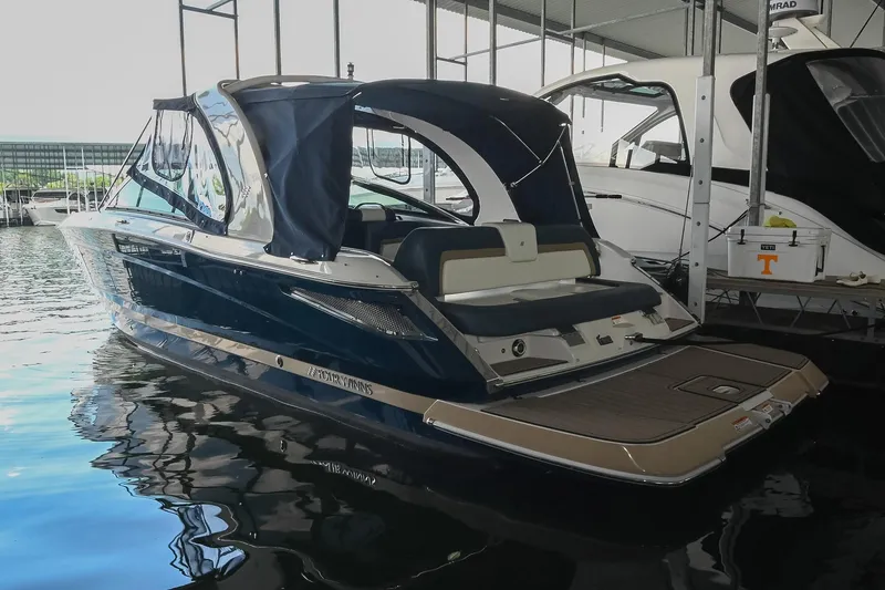 Slide: The Image of 2014 Four Winns H290 boat docked in a marina, featuring a sleek design and canopy. - 3