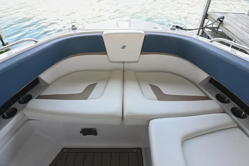 Slide: The Image of Interior seating of 2014 Four Winns H290 boat, featuring white and blue cushioned seats. - 31