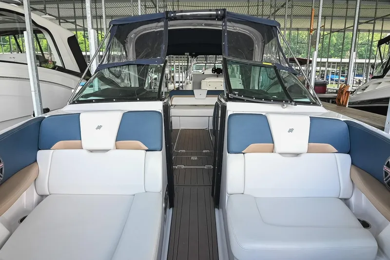 Slide: The Image of 2014 Four Winns H290 boat interior with blue and white seating in a marina. - 33