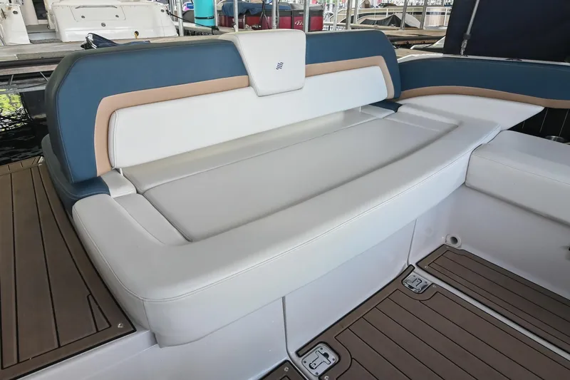Slide: The Image of 2014 Four Winns H290 boat seating with blue and tan accents, docked in a marina. - 9