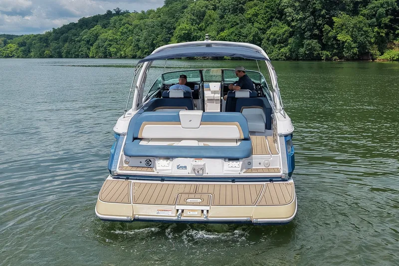 Slide: The Image of 2014 Four Winns H290 boat cruising on a scenic lake with lush green shoreline. - 3