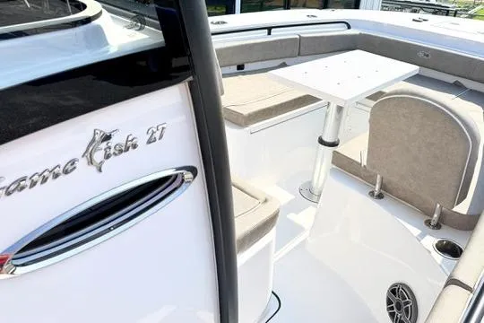 Slide: The Image of 2026 Sea Hunt Gamefish 27 Forward Seating boat interior with cushioned seats and table. - 24