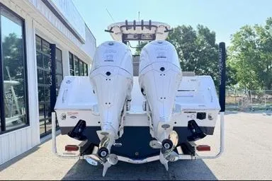 Slide: The Image of 2026 Sea Hunt Gamefish 27 boat with dual outboard engines, parked outdoors. - 3