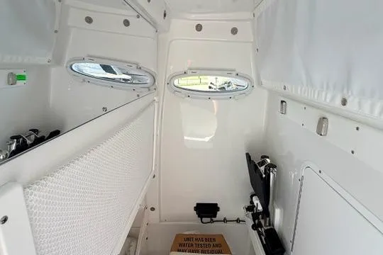 Slide: The Image of Interior cabin of 2026 Sea Hunt Gamefish 27 Forward Seating boat, featuring white walls and portholes. - 35
