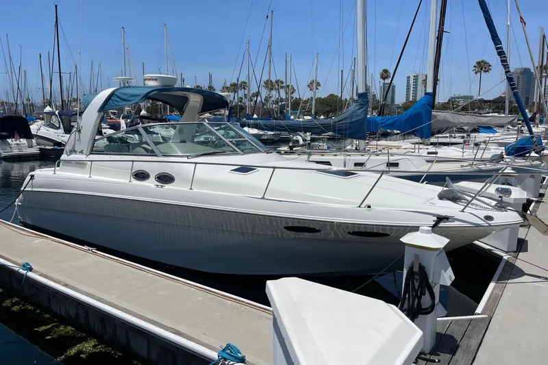 The Image of 2000 Sea Ray Sundancer 310 docked at marina with sailboats in background. - 0