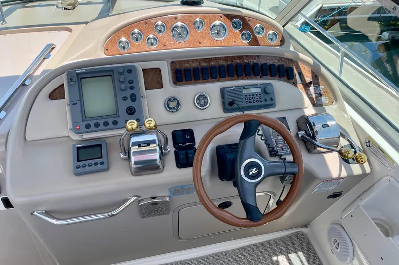 Slide: The Image of Control panel of a 2000 Sea Ray Sundancer 310 boat with steering wheel and navigation instruments. - 13