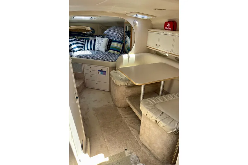 Slide: The Image of Interior of 2000 Sea Ray Sundancer 310 with cozy seating and striped bedding. - 14