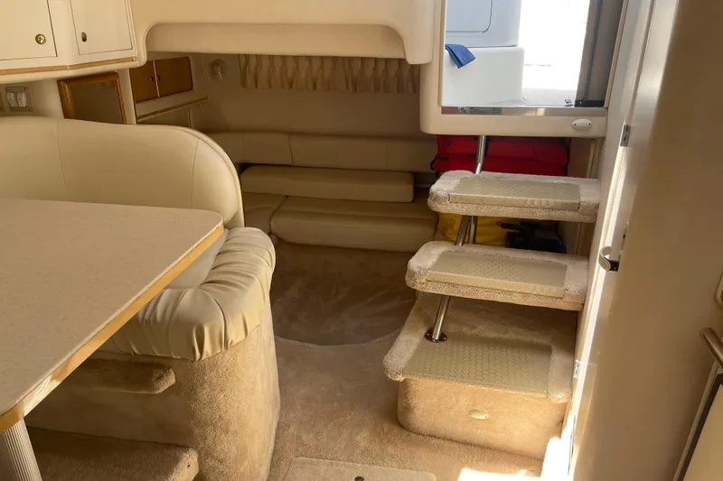 Slide: The Image of Interior of 2000 Sea Ray Sundancer 310 yacht, featuring beige seating and carpeted steps. - 25