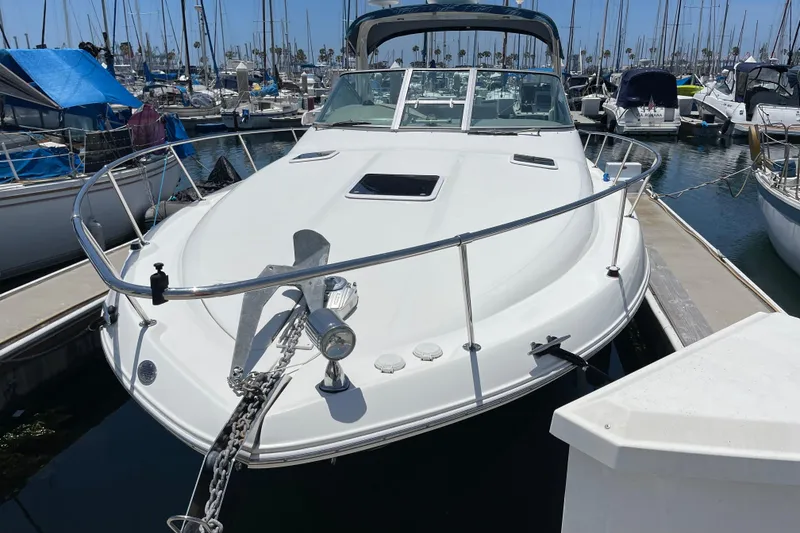Slide: The Image of Sea Ray Sundancer 310, 2000 model, docked in a marina with surrounding boats. - 3