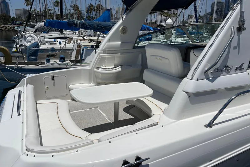 Slide: The Image of 2000 Sea Ray Sundancer 310 yacht interior with seating and table, docked at marina. - 7